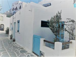 a white building with a blue door on a street at Stella' s house Castle of Chora Naxos in Naxos Chora