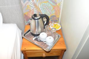 a tray with a tea kettle and cups on a table next to a bed at Marianna's Rooms in Skala Eresou