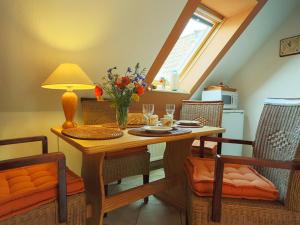 a dining room table with a vase of flowers on it at Fewo im Herzen der Insel in Bergen auf Rügen