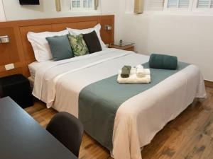 a bedroom with a large bed with two towels on it at Casa da Marquês in Petrópolis