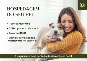 a woman holding a dog in her arms at Hotel Itamarati Centro-República in Sao Paulo