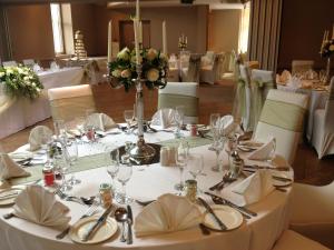 a table set up for a wedding with white table settings at Regent Hotel Doncaster in Doncaster