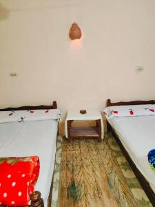 a room with two beds and a table in it at Sunset Mirage in Luxor