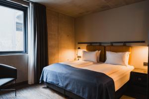 een slaapkamer met een groot bed met een groot raam bij Exeter Hotel in Reykjavík +71 foto's