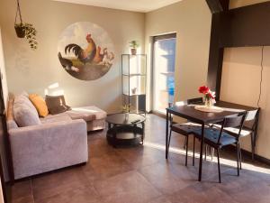 a living room with a couch and a table with chickens on the wall at de Loeiende koe in Liessel