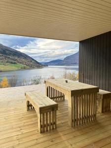 a wooden deck with benches and a view of a lake at Olden Apartment with Panorama view in Olden