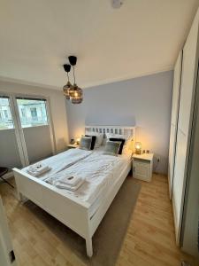 une chambre avec un grand lit blanc dans une pièce dans l'établissement Schönes Zwei-Zimmer-Apartment in der Bremer City, à Brême