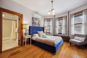 圣保罗Historic District BnB的一间卧室，里面有一张床、一把椅子和几扇窗户。