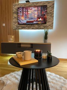 a table with cups and candles on it in a room at DespotLux & Spa Zlatibor in Zlatibor