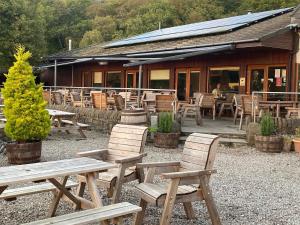 a group of wooden tables and chairs in front of a building at The Old Shed in Benderloch