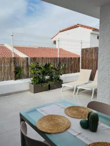 un patio con tavolo in vetro e sedie sul balcone. di Endless Summer Suite - swimming pool - AC ad Adeje