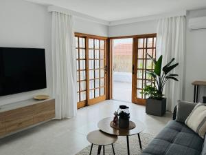 un soggiorno con TV e divano di Endless Summer Suite - swimming pool - AC ad Adeje