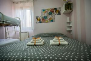 a bedroom with a bed with towels on it at QuattroQuattroQuattro in Porto San Giorgio