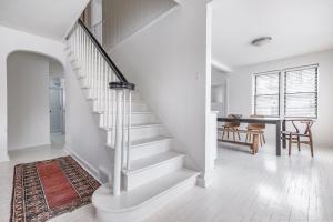 a white staircase in a living room with a table at Hygge House in Harbert +44 photos