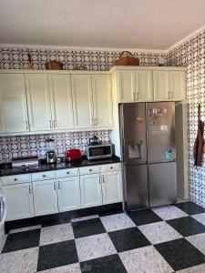 a kitchen with white cabinets and a refrigerator at La Casona de Barganaz in Ranón