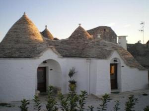 une petite maison blanche avec un toit dans l'établissement La Trullesa Holiday, à Alberobello