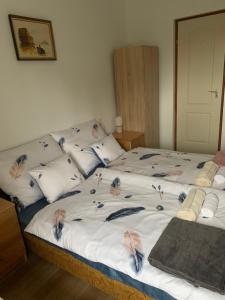 a bed with pillows with birds on it at Fehér Bagoly Vendégház in Kovácsszénája