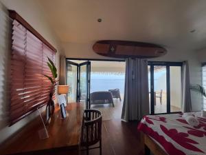 - une chambre avec un bureau et une vue sur l'océan dans l'établissement Ocean Breeze Bungalow, à Tevaitoa