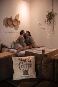 Dos personas sentadas en una cama en una habitación. en Cabana na montanha com Ofurô ao ar livre, churrasqueira, trilha com cascata e Starlink, en Cambuí