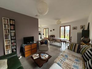 a living room with a couch and a table at Maison Familiale en Cévennes in Le Salson