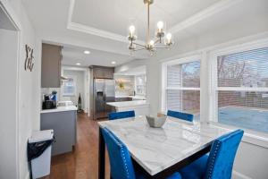 a kitchen with a dining table and blue chairs at Main Street Oasis Pool and Hot Tub Sleeps 8 in Hamilton