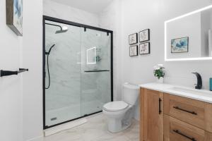 a bathroom with a shower and a toilet and a sink at Chez Dodo Chalet Tremblant 3bdrs condo with fireplace in Mont-Tremblant +17 photos