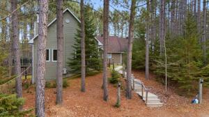 a small house in the woods with trees at Chez Dodo Chalet Tremblant 3bdrs condo with fireplace in Mont-Tremblant