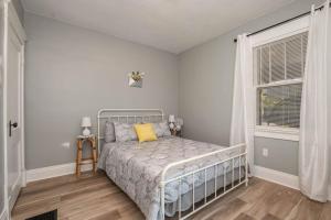 ein Schlafzimmer mit einem Bett und einem Fenster in der Unterkunft Dayton Street Sports Haven - 3 Bed 2 Bath Sleeps 8 in Hamilton