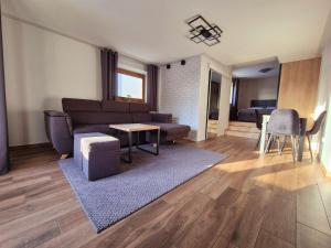 a living room with a couch and a table at Apartament Pod Danielkami in Podwilk