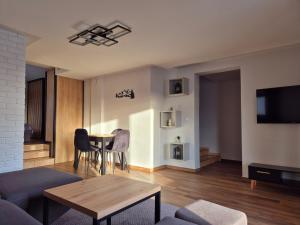 a living room with a couch and a table at Apartament Pod Danielkami in Podwilk