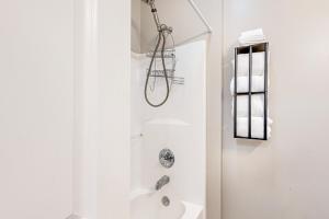 Un baño blanco con ducha y lavabo. en Sea 2 Green, en Pawleys Island 16 fotos más
