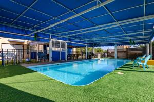 a large swimming pool with a blue roof at עדי הכרמל in Dāliyat el Karmil