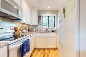 a kitchen with white cabinets and a white refrigerator at Bayfront Retreat B in Port Ludlow
