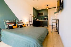a bedroom with a large bed and a kitchen at Le studio tendance in Albi