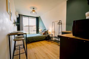 a bedroom with a bed and a desk with a bar at Le studio tendance in Albi