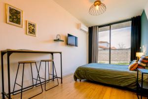 a bedroom with a bed and a desk and a window at Le studio tendance in Albi