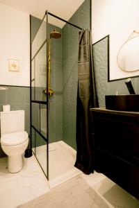 a bathroom with a toilet and a glass shower at Le studio tendance in Albi +5 photos