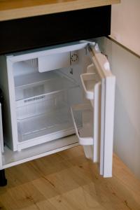 an empty refrigerator with its door open in a kitchen at Le studio tendance in Albi
