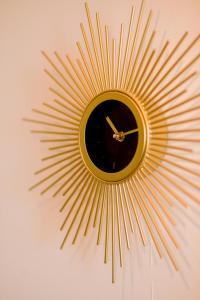 a gold sunburst clock hanging on a wall at Le studio tendance in Albi