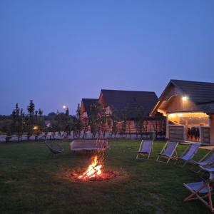 a fire in a yard with chairs and a table at Domki Wojtasówka in Obrazów