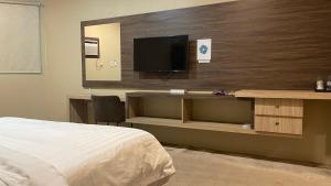 a bedroom with a bed and a desk with a television at فندق دلسDELS HoTEL in Tabuk