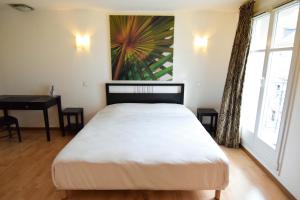 米盧斯的住宿－渣油姆豪斯中央酒店，卧室配有一张床、一张书桌和窗户。