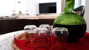 a table with a vase and four glasses on it at GuestHouse Pombinha in Nazaré