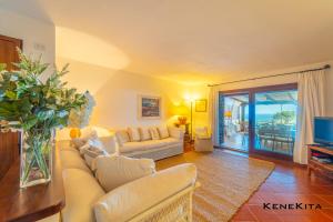 una sala de estar con sofá y un jarrón de flores en Dream the Sea, en Porto Rotondo