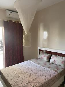 a bedroom with a large bed with a canopy at Keur Massar tollou laye wade in Dakar +9 photos