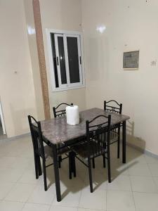 a dining room table with chairs and a window at Keur Massar tollou laye wade in Dakar