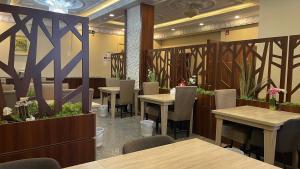 a restaurant with tables and chairs and plants at فندق دلسDELS HoTEL in Tabuk