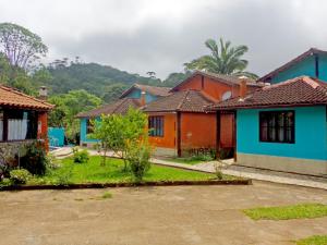 une rangée de maisons colorées dans un village dans l'établissement Pousada Chalés Vista da Serra, à Visconde de Mauá