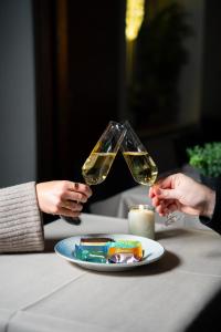dos personas sosteniendo copas de vino sobre un plato de comida en Palads Hotel, en Viborg 13 fotos más