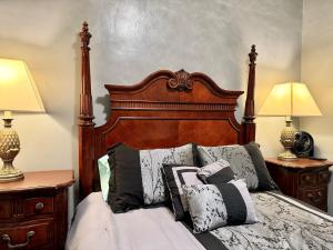 a bed with a wooden headboard and pillows on it at Cozy 1 BR, walk to subway, Free WiFi & Parking in Belleville